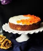 white and orange icing-coated cake on scalloped edge white ceramic cake stand